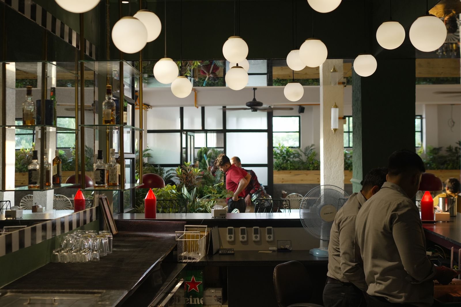 The Shalimar bar — glass globe lights and a wall of whiskey