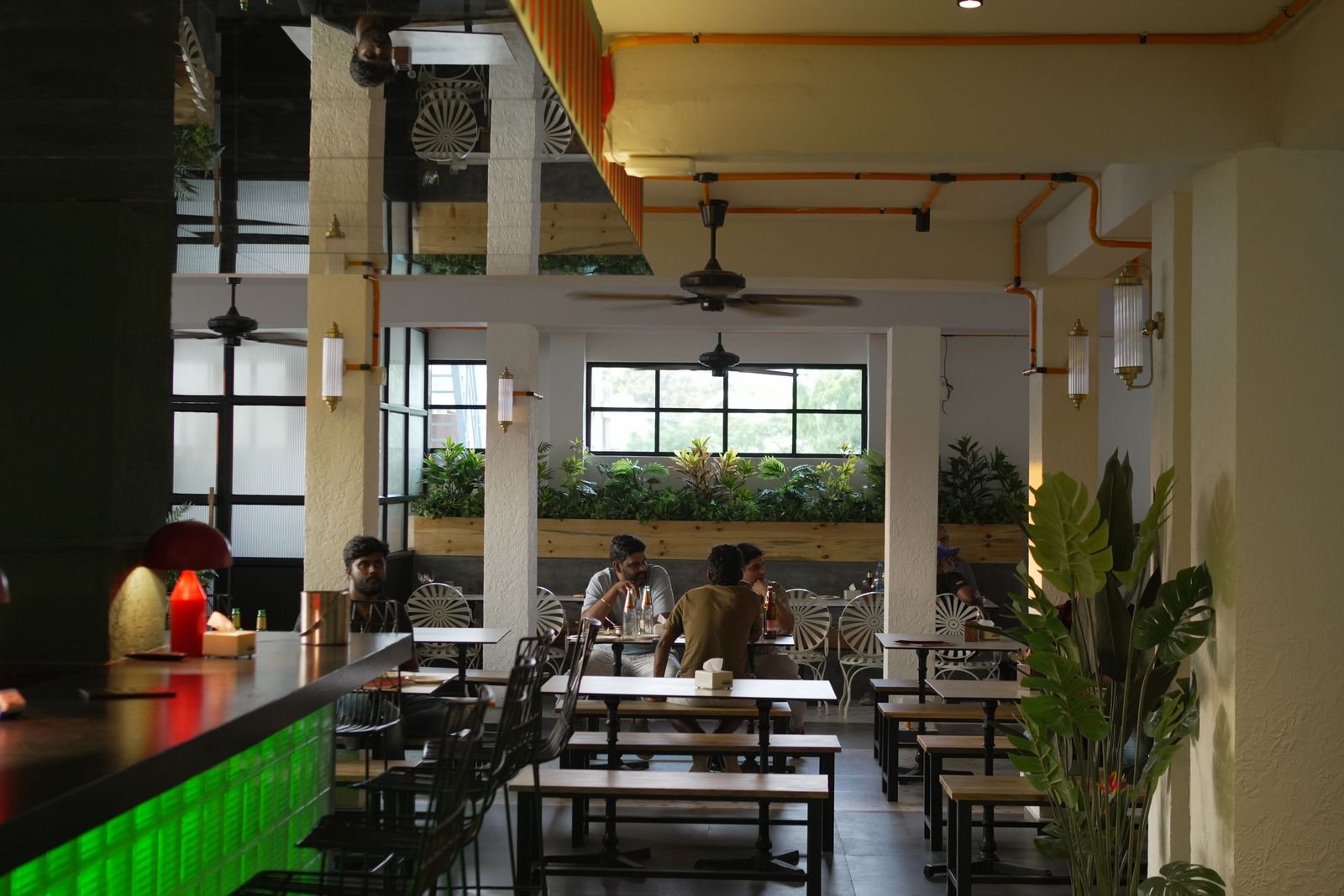 The Shalimar dining room — warm light, long tables and greenery